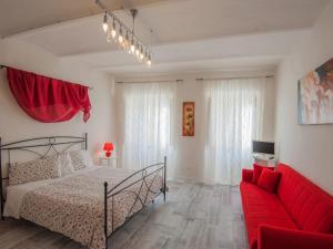 ein Schlafzimmer mit einem Bett und einem roten Sofa in der Unterkunft La Pieve in Arezzo