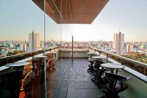 a balcony of a restaurant with tables and chairs at Hotel Bertaso in Chapecó