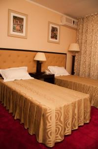 a hotel room with two beds and a red carpet at Hotel Baden in Călăraşi