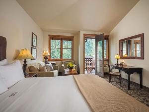 a bedroom with a large bed and a living room at The Hotel Telluride in Telluride