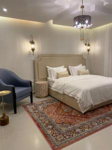 a bedroom with a bed and a chair and a rug at شقق بيت العز Bait Alez in Jeddah
