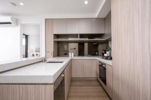 a kitchen with white counters and a large counter top at Luxury Bay View Apartment in Melbourne