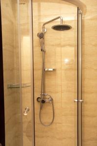 a shower with a glass door and a shower head at Hotel Baden in Călăraşi +23 photos
