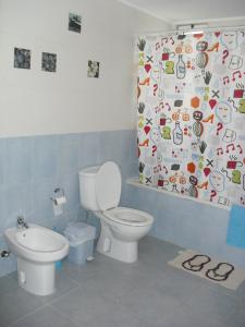 a bathroom with a toilet and a shower curtain at São Roque Apartment in São Roque