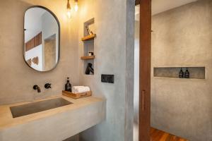 un baño con lavabo y espejo en Modern Uluwatu Studio Apartment and Pool, en Uluwatu 32 fotos más