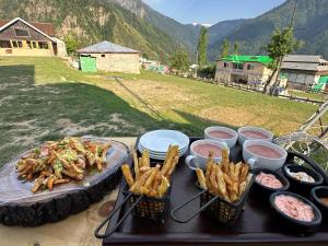 Luxury Timber Resorts and Hotels Cottages in Upper Neelum, Keran, AJK في Chak: طاولة مع صينية طعام وبطاطس مقلية +32 صورة