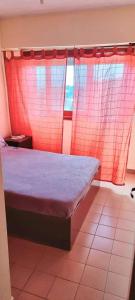 1 dormitorio con 1 cama con cortinas rojas y ventana en LaCasitaBlanca, en Las Toninas 13 fotos más