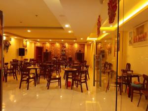 a restaurant with tables and chairs in a room at Ngũ Long Hai Hotel in Vĩnh Long