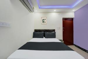 una camera con letto bianco e soffitto blu di Hotel O Gajraj Banquet Hall Guest House a Gulzārbāgh Altre 21 foto