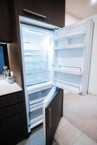 an empty refrigerator with its door open in a kitchen at Cozy Spacious Holiday 2B2B Melbourne CBD Apartment in Melbourne