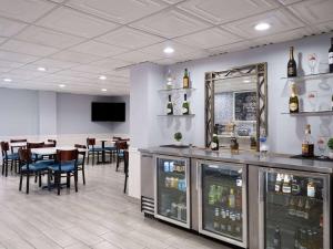 a restaurant with a bar with a table and chairs at AmericInn by Wyndham Woodstock IL in Woodstock