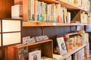 a book shelf filled with lots of books at Guesthouse SETOUCHI LIFE in Kure