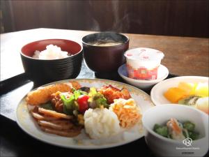 a table with a plate of food and bowls of food at Daiwa Roynet Hotel Mito in Mito