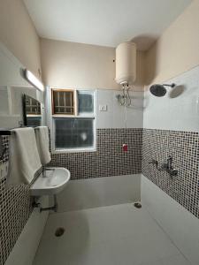 a bathroom with a sink and a toilet and a window at Red Brick Retreat G floor 3BHK in Lucknow