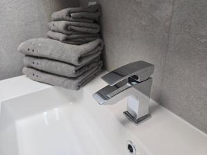 a bathroom sink with a faucet and a pile of towels at Citycenter Salzburg am Ursulinenplatz in Salzburg +20 photos