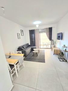una sala de estar con un sofá y una mesa en EilatCasa, en Eilat