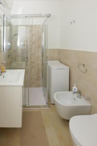 a bathroom with a toilet and a sink and a shower at Astro apartments with direct access on the sea of Noto heritage of Unesco in Noto