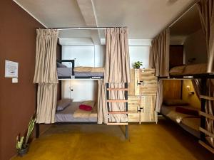 una stanza con tre letti a castello in una stanza di Beyond Nomad Luxury Hostel a Ella