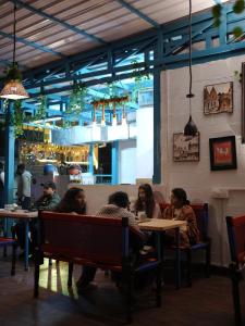 a group of people sitting at tables in a restaurant at Yes Retreat Rishikesh in Rishīkesh