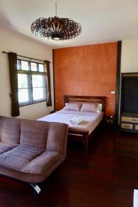 a living room with a bed and a couch at Banjai Garden Guesthouse in Chiang Mai