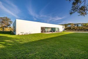 een wit huis met een grote tuin bij Vila D`Obidos in Casal da Lagoa Seca
