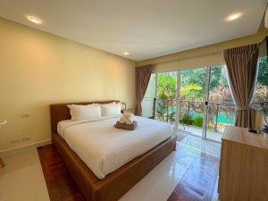 a bedroom with a bed with a teddy bear on it at Oasis 1 Bedroom Apartment In Rawai in Phuket Town +61 photos