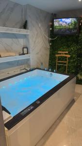 Cette chambre dispose d'une télévision et d'une grande baignoire bleue. dans l'établissement Hébergement jacuzzi très silencieux, à Deuil-la-Barre 30 autres photos