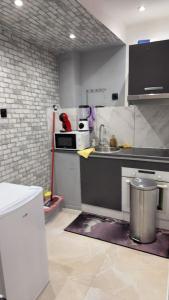 une cuisine avec un évier et un micro-ondes dans l'établissement Hébergement jacuzzi très silencieux, à Deuil-la-Barre