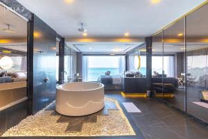 a large bathroom with a tub in the middle at Baancoconutkohlarn in Ko Larn