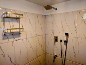 Habitación con una pared de azulejos blancos y 2 parquímetros. en The Whitegates Lodge, en Weligama