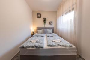 a bedroom with a large bed with two pillows at Panorama Home Apartman in Balatonkenese