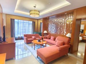 a living room with orange couches and a table at Pullman Zhangjiajie Hotel - Instagrammable in Zhangjiajie