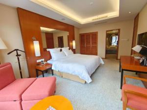 a hotel room with a large bed and a couch at Pullman Zhangjiajie Hotel - Instagrammable in Zhangjiajie