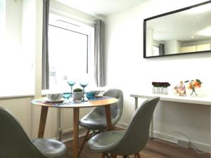 Una mesa de comedor con sillas y un espejo. en Luxurious Home Tottenham Court Road CharingCross Leicester Square, en Londres