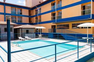 a swimming pool in front of a building at INTER HOTEL JACARAÍPE in Serra