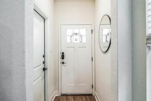 una puerta blanca en un pasillo con espejo en Modern 3BR in Gated Community Near JBSA & SeaWorld Duplex, en San Antonio