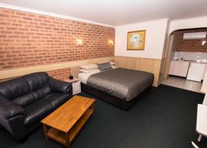 a hotel room with a bed and a couch at Colonial Motor Inn Bairnsdale Golden Chain Property in Bairnsdale