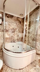 a bath tub in a bathroom with a glass wall at The Green Park Taksim in Istanbul