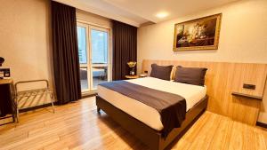 a bedroom with a bed and a large window at The Green Park Taksim in Istanbul