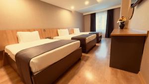 a hotel room with two beds and a desk at The Green Park Taksim in Istanbul