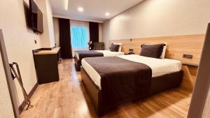 a hotel room with two beds and a flat screen tv at The Green Park Taksim in Istanbul +26 photos