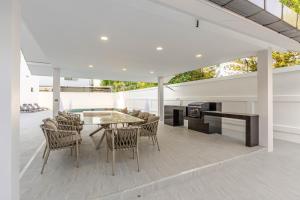 ein Esszimmer mit einem Tisch und Stühlen auf einer Terrasse in der Unterkunft T M L- Grand Villa 6 Bedroom 8 Bathroom in Ban Bung
