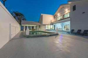 ein großes Haus mit einem Swimmingpool im Hof in der Unterkunft T M L- Grand Villa 6 Bedroom 8 Bathroom in Ban Bung