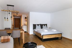 Un dormitorio con una cama y un comedor. en Rothornblick 50 by Arosa Holiday, en Arosa