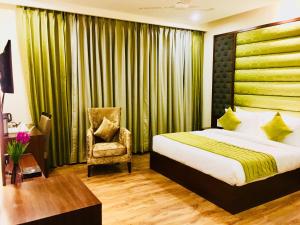 a hotel room with a bed and a chair at Hotel Bahl Regency in Zirakpur