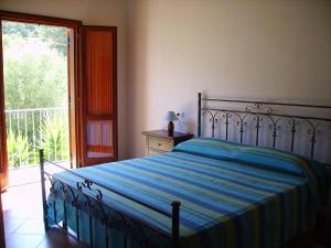 um quarto com uma cama com um cobertor listrado azul em Agriturismo La Grotta Del Tesoro em Santadi