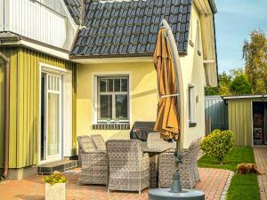 a patio with an umbrella and chairs and a table at Ferienhaus Mee(h)rZeit in Zingst