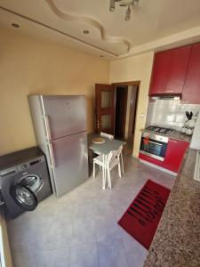 a kitchen with a stainless steel refrigerator and a table at Dar mayssane in Agadir