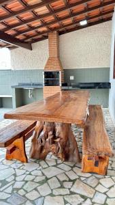 a large wooden table with a large tree stump table at Casa na Praia do Morro Grande e Muito Arejada in Guarapari