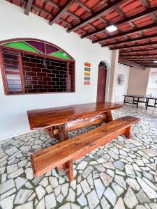 a wooden bench sitting on a stone floor in a room at Casa na Praia do Morro Grande e Muito Arejada in Guarapari